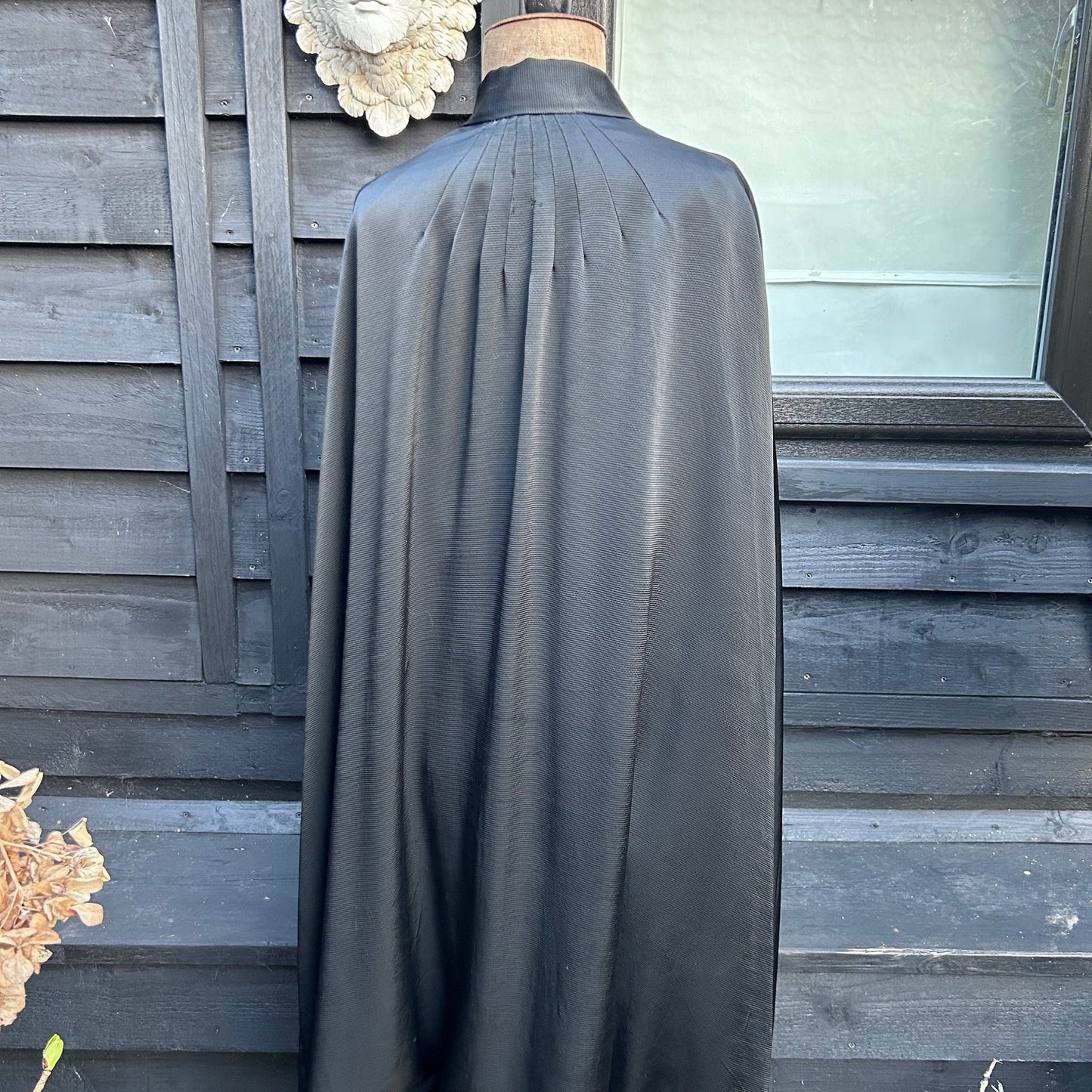 back view of Antique black silk opera cape on mannequin against building with window - Splendid Vintage World