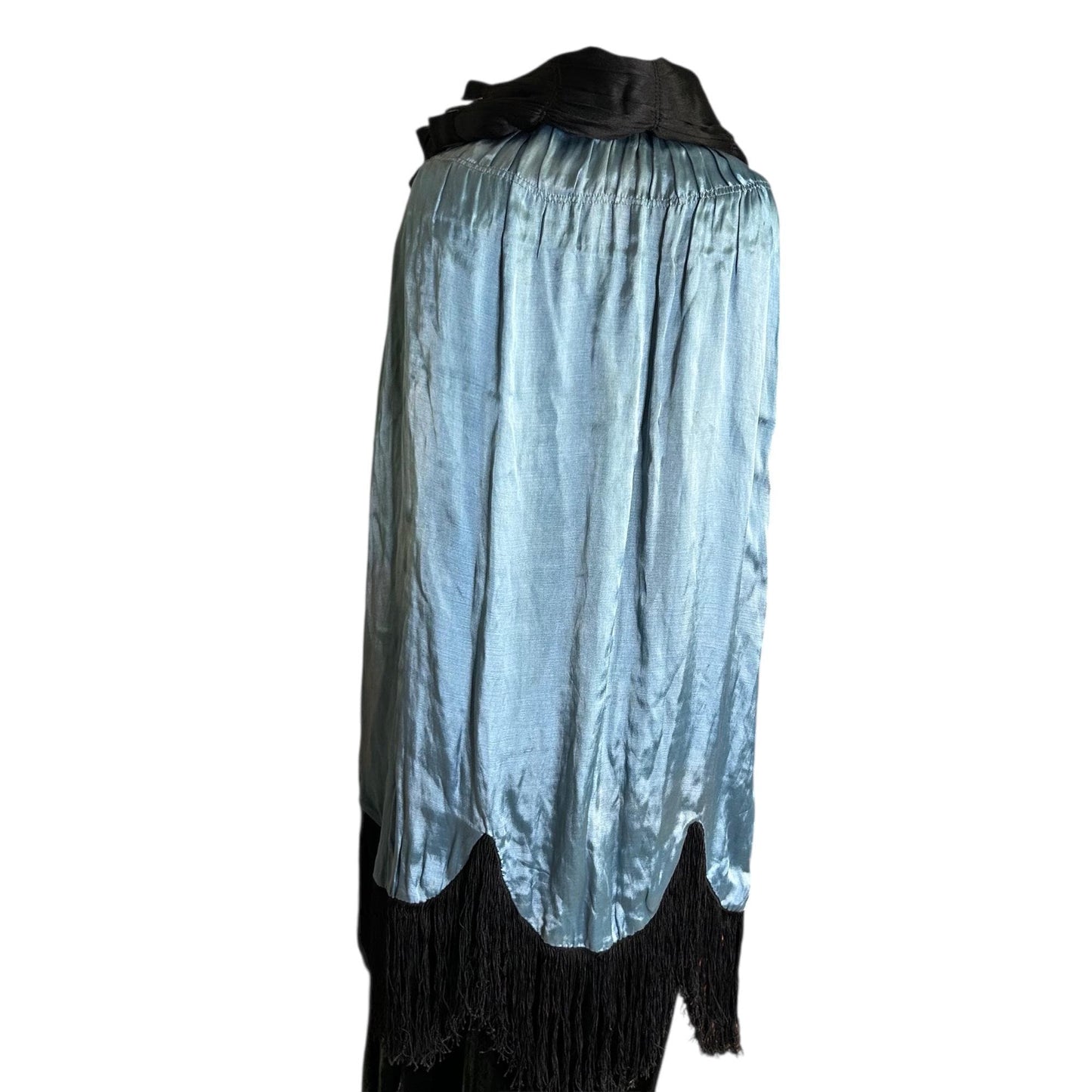 1920s 1930s Blue lining of black cape with silk fringe over black skirt on mannequin white backdrop - Splendid Vintage World