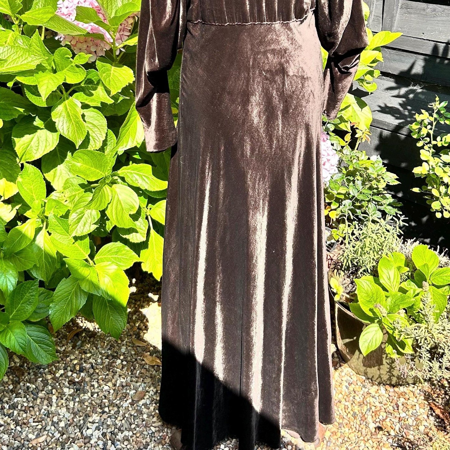 1930s Dark Brown long Velvet Coat against green plants and stone - Splendid Vintage World