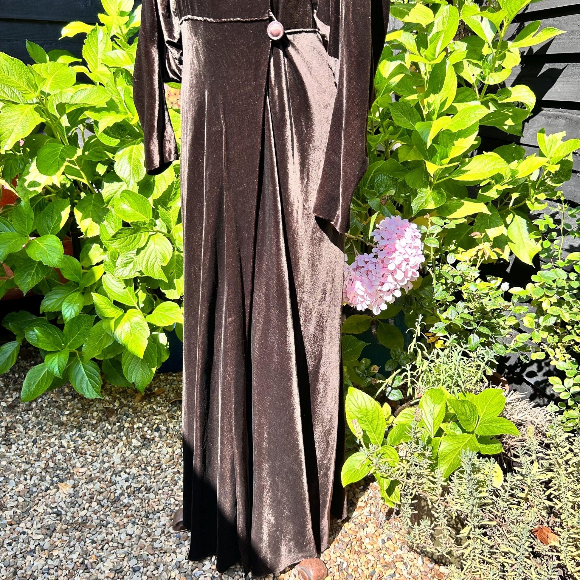 Dark Brown long Velvet Coat against green plants and stone - Splendid Vintage World