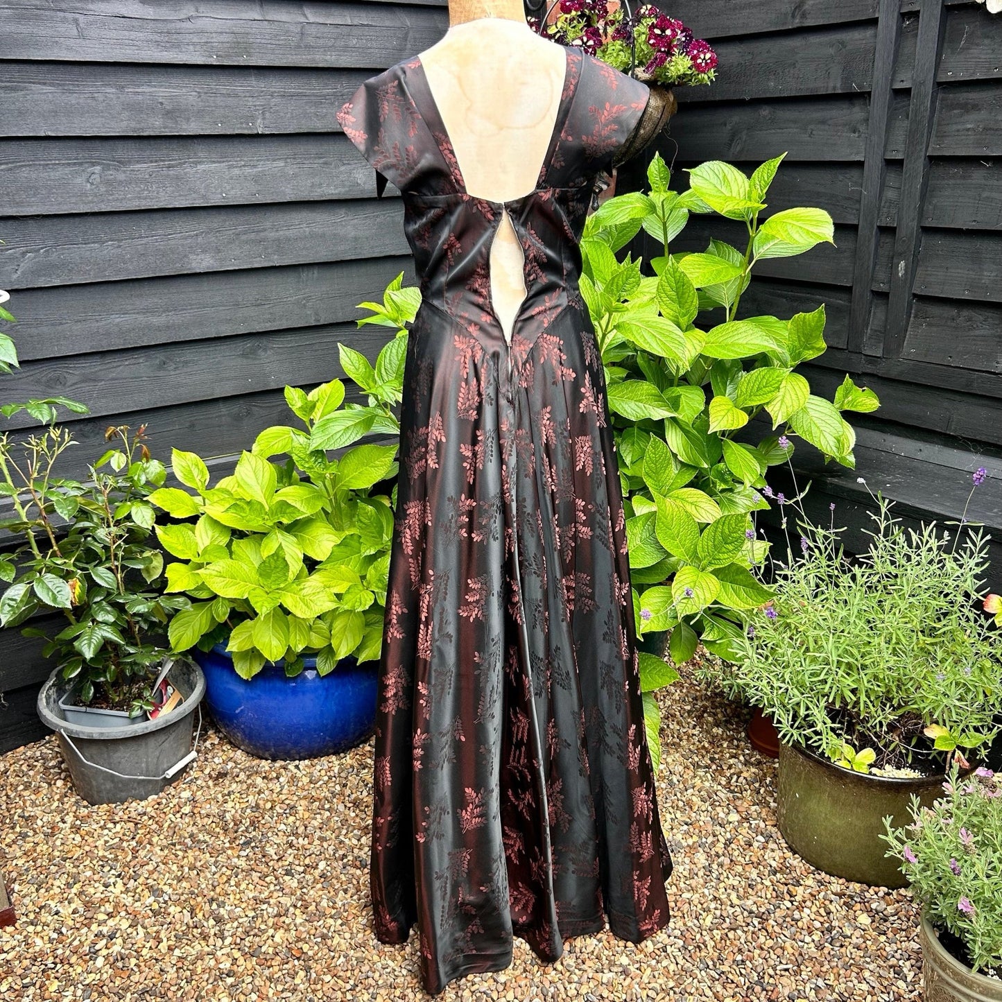 1950s long evening dress black & pink floral damask back view in garden setting  - Splendid Vintage World