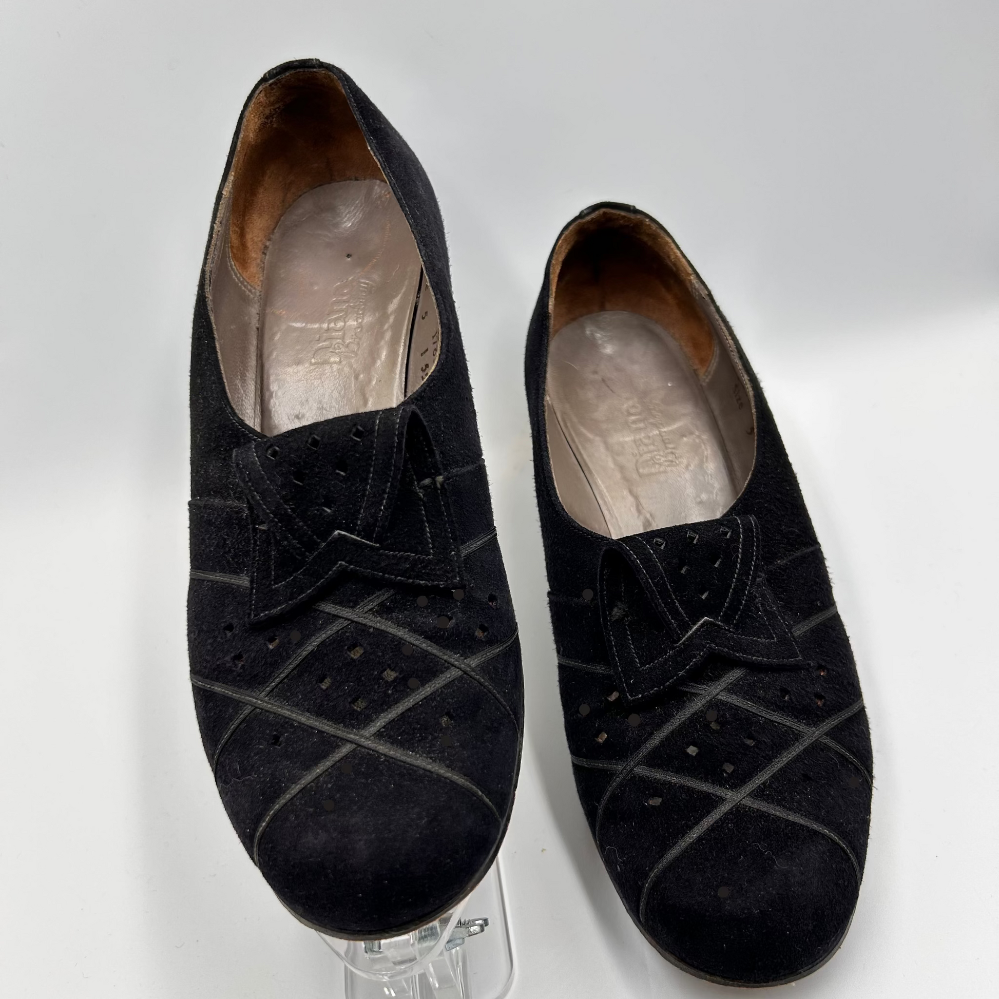 Pair of black suede shoes on a white background
