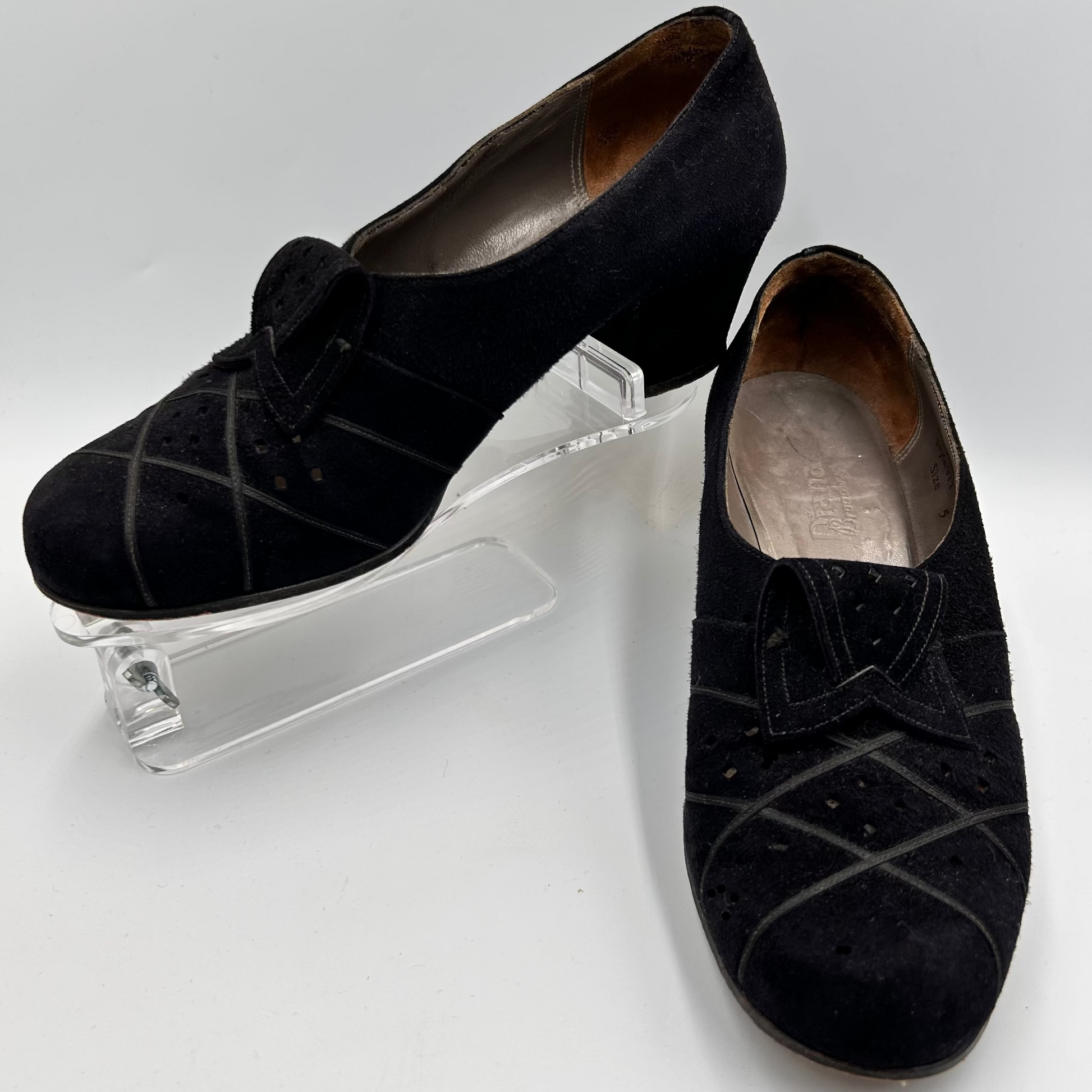 Pair of black suede shoes on a white background