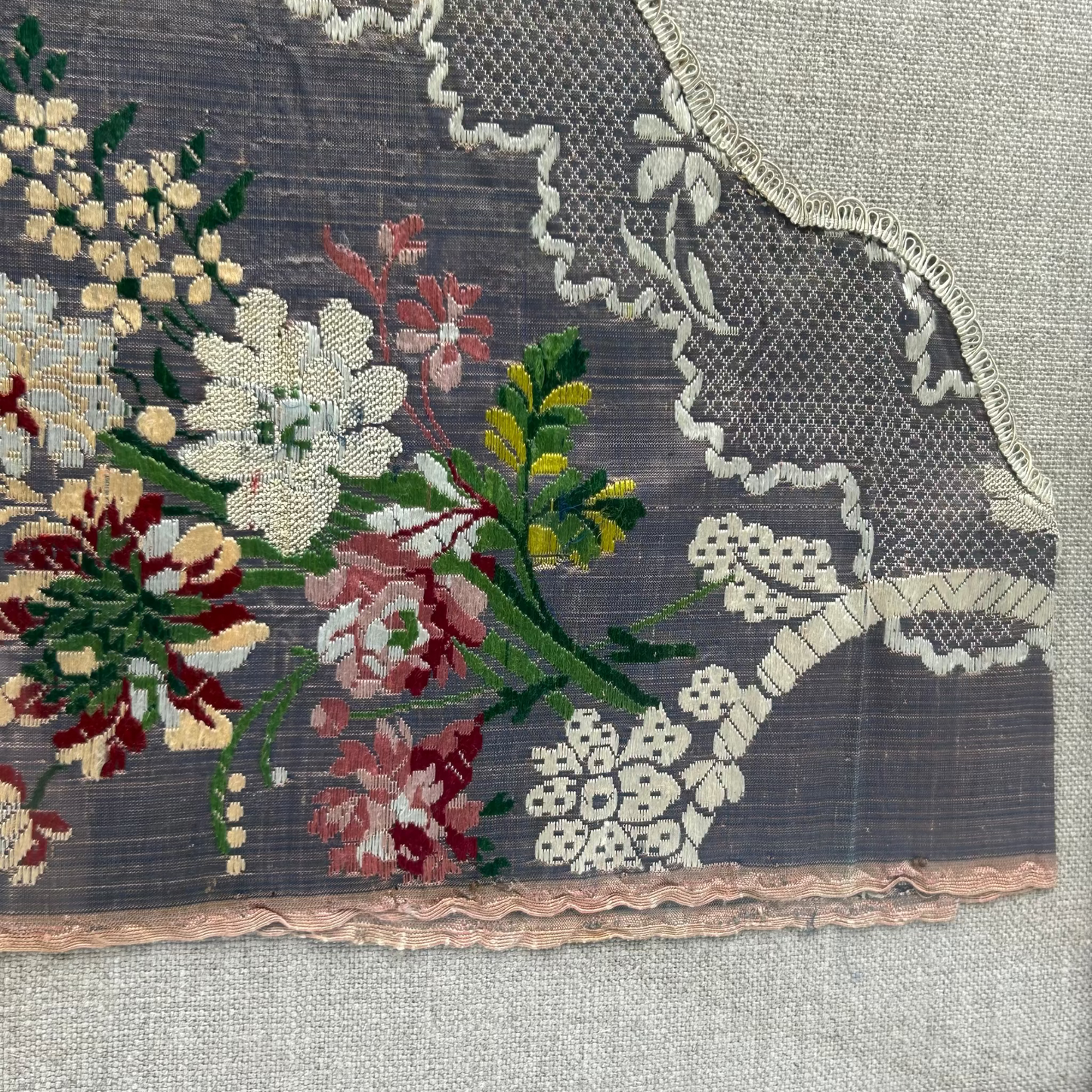 Embroidered floral pattern on fabric with lace trim