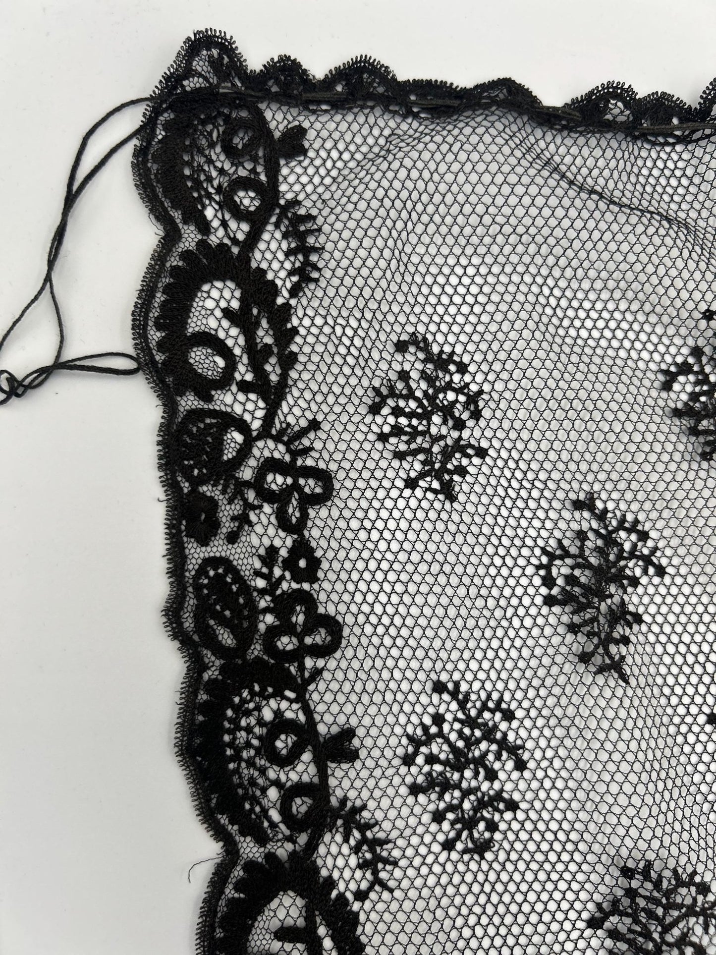 Antique black lace bonnet veil, lace panel with drawstring close up detail on white background