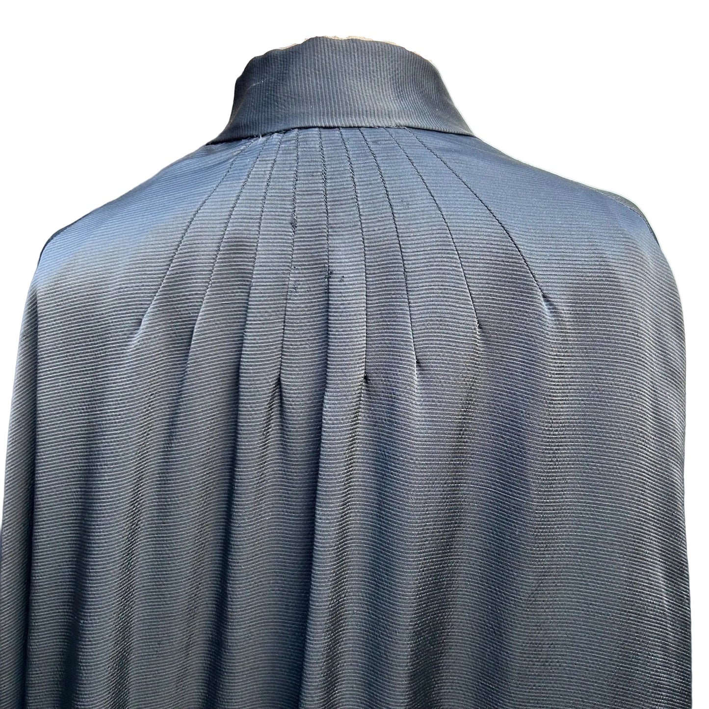 close up of back neckline of Antique black silk cape sun ray seaming against white background - Splendid Vintage World
