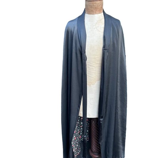Antique black silk opera cape open at the front on a mannequin against white background - Splendid Vintage World