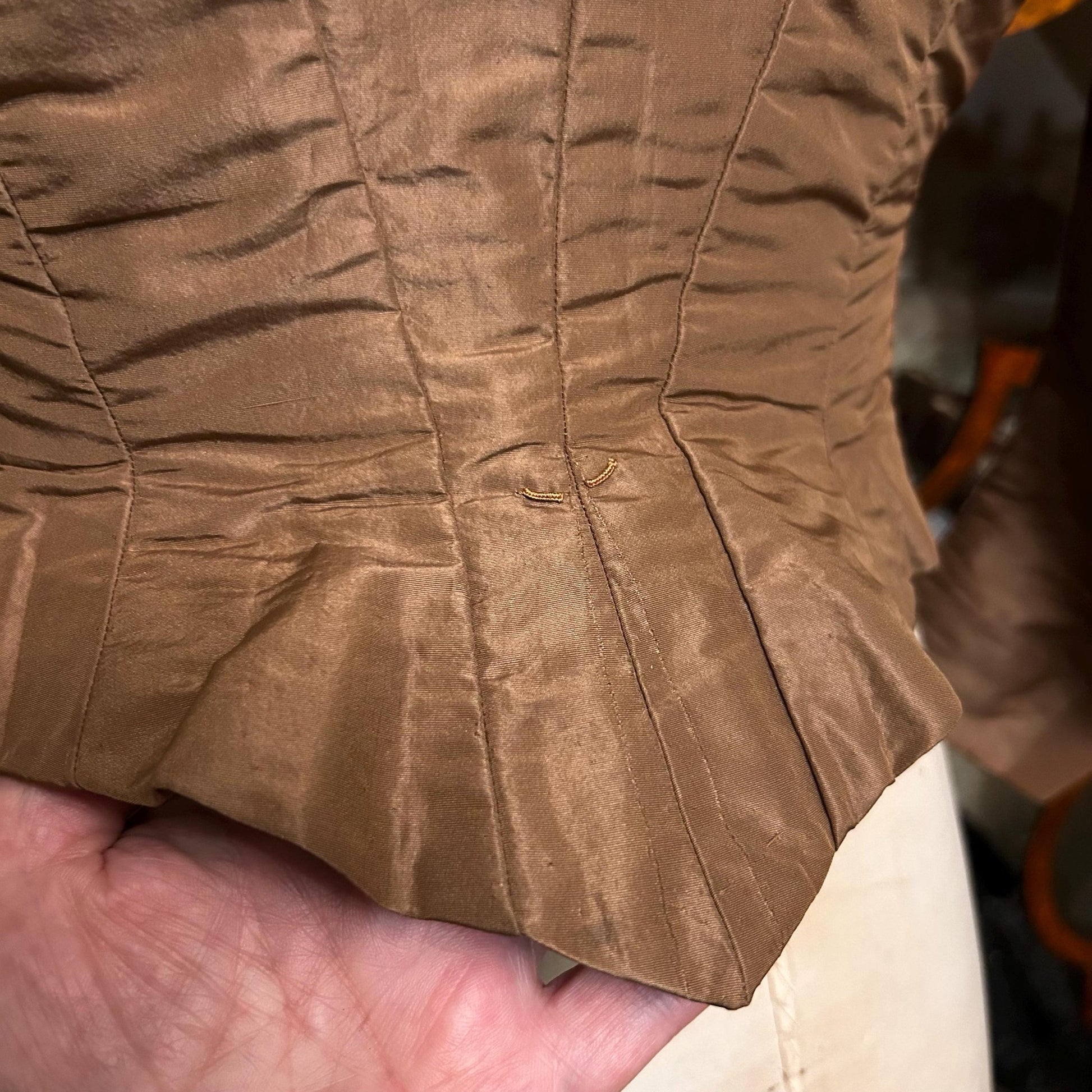 Antique bodice in brown copper moire silk back hem detail against hand - Splendid Vintage World