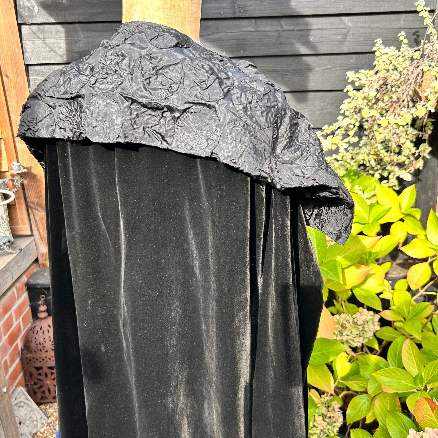 Art Deco black velvet cocoon cape with feature collar back view on mannequin in garden - Splendid Vintage World
