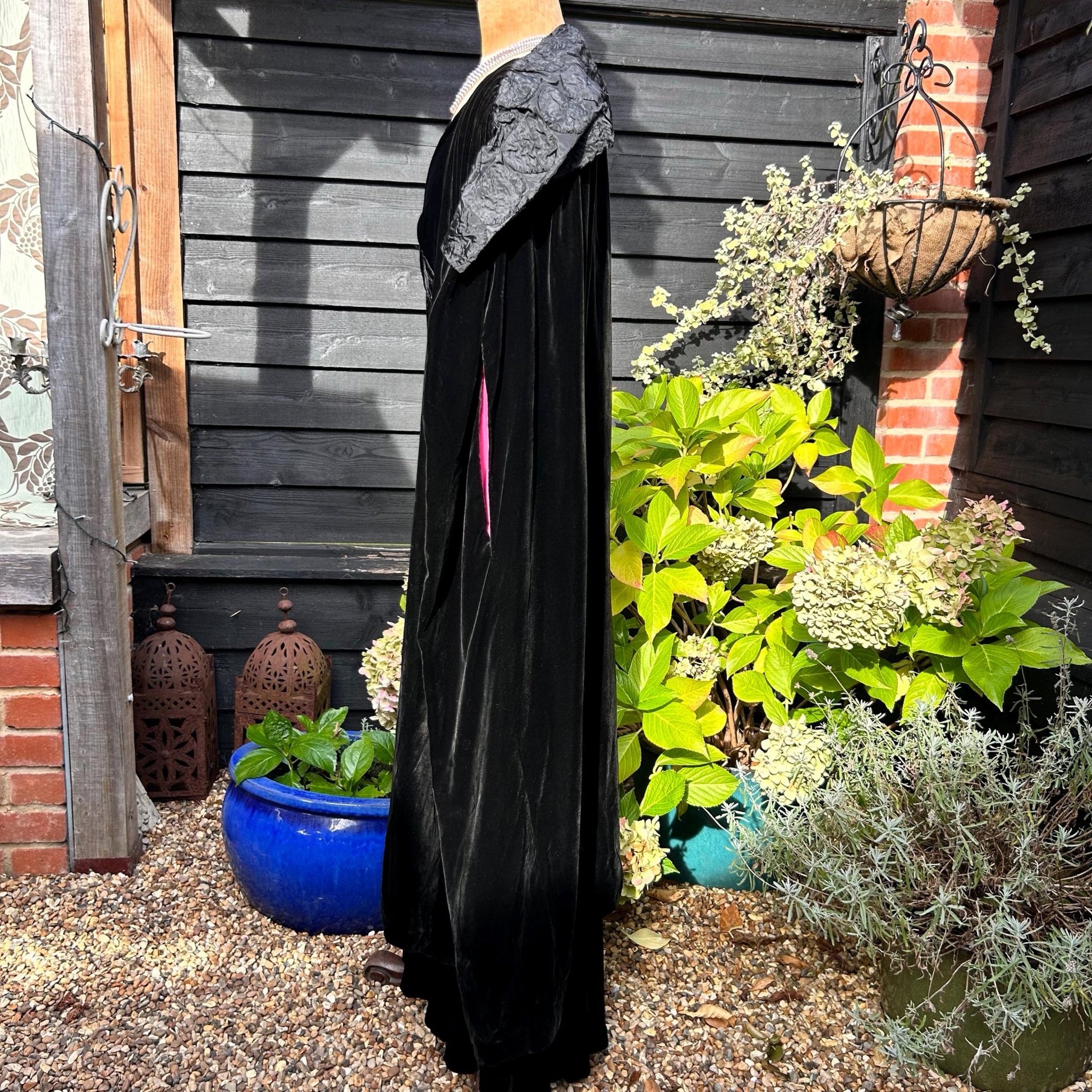 Art Deco black velvet cocoon cape with feature collar side view in garden setting - Splendid Vintage World
