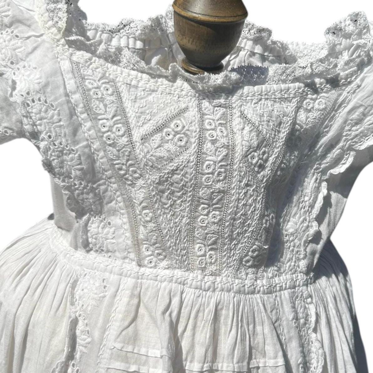 White Cotton Embroidered christening bodice close up on white ground - Splendid Vintage World