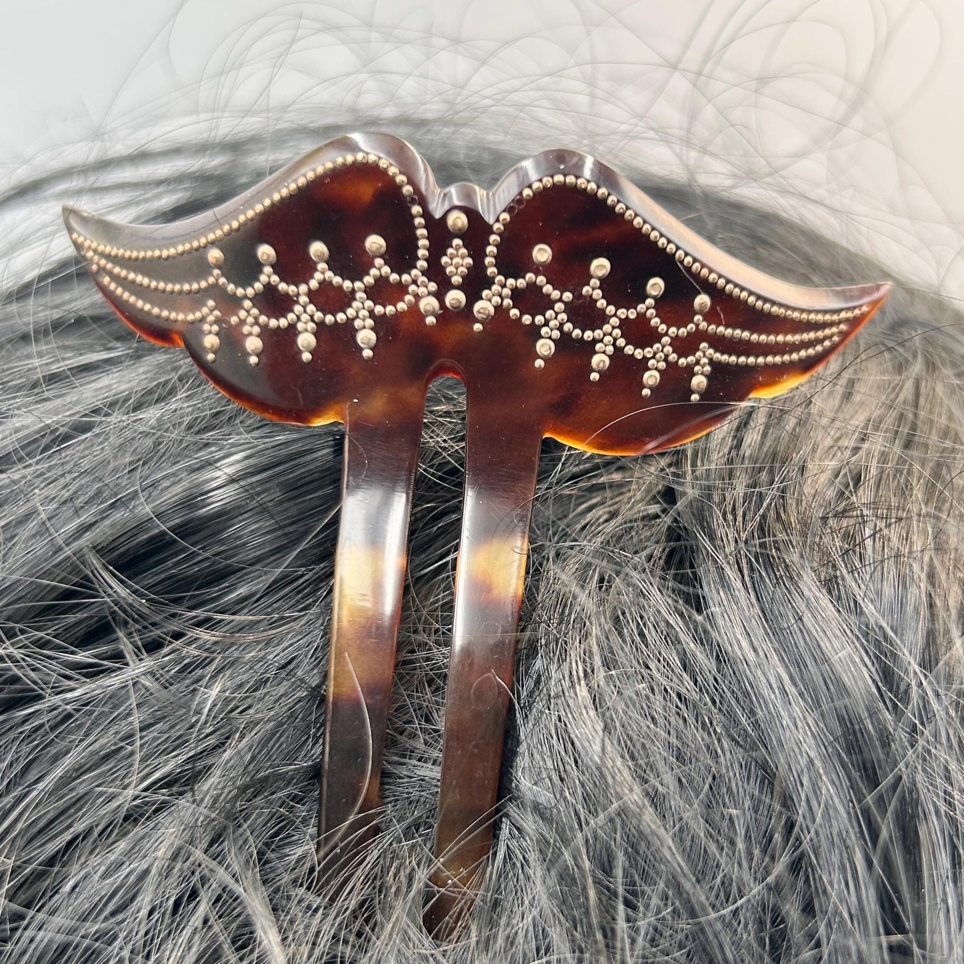 Antique Edwardian faux tortoiseshell hair pin decoration in black hair on grey background  - Splendid Vintage World