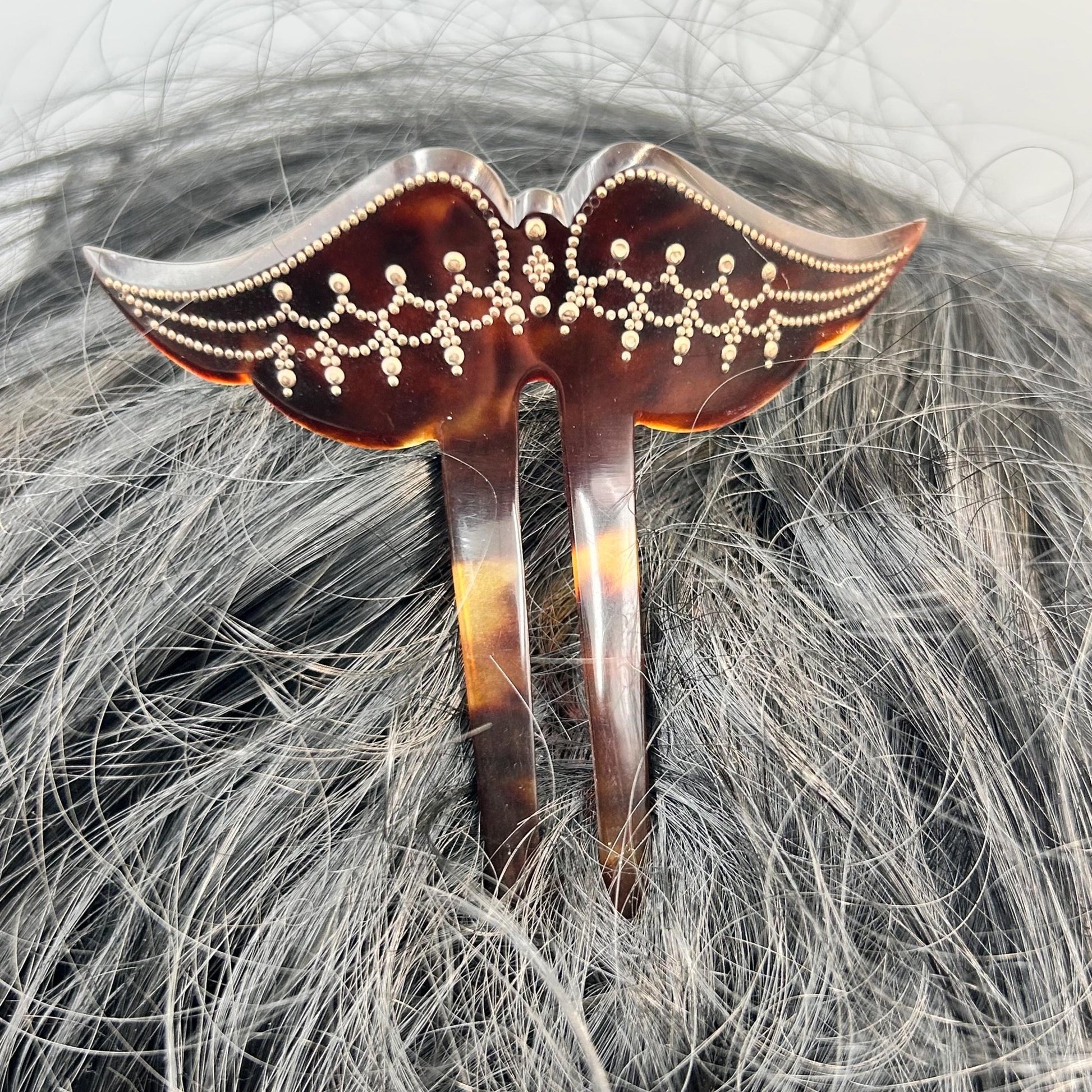 Edwardian faux tortoiseshell hair pin decoration in black hair against grey background - Splendid Vintage World
