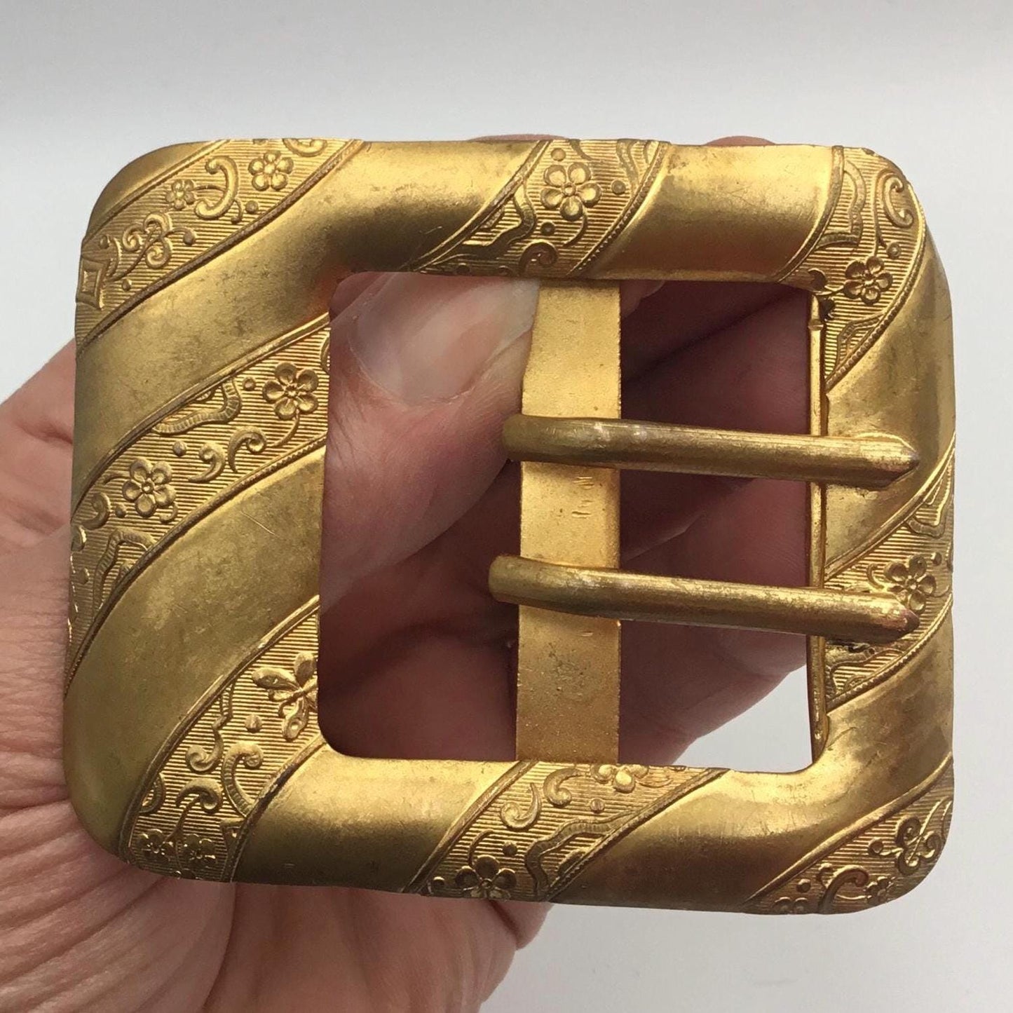Antique Edwardian gilt metal buckle With floral & butterfly detail in between plain diagonal bands - Splendid Vintage World