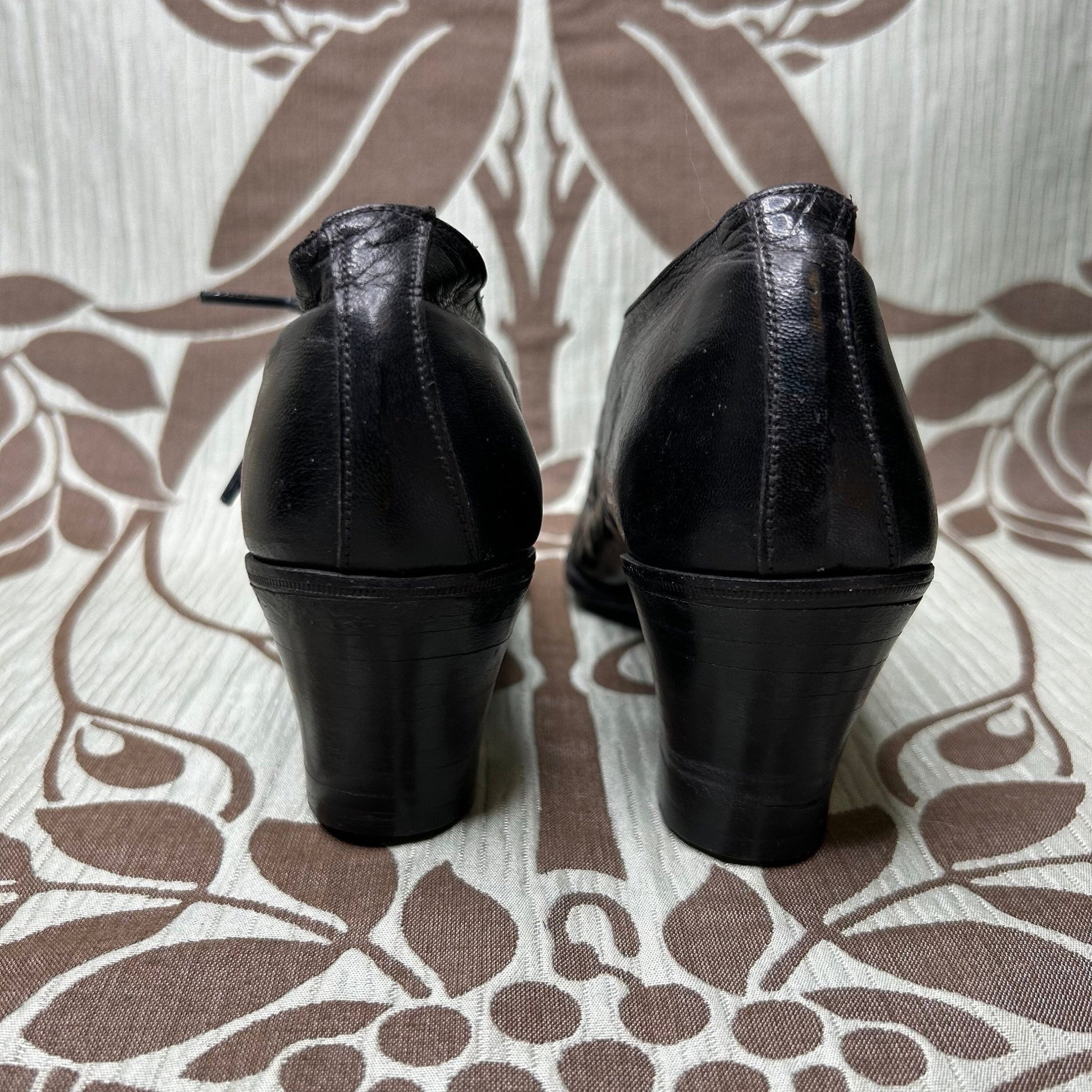 back heel view of Edwardian Ladies black leather Oxford heeled shoes on patterned fabric - Splendid Vintage World