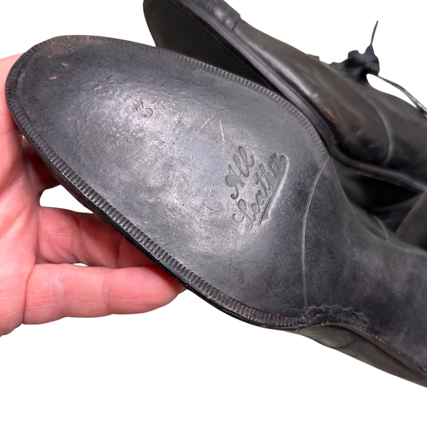 hand holding Edwardian Ladies black leather lace up Oxford heeled shoe sole  against white backdrop - Splendid Vintage World