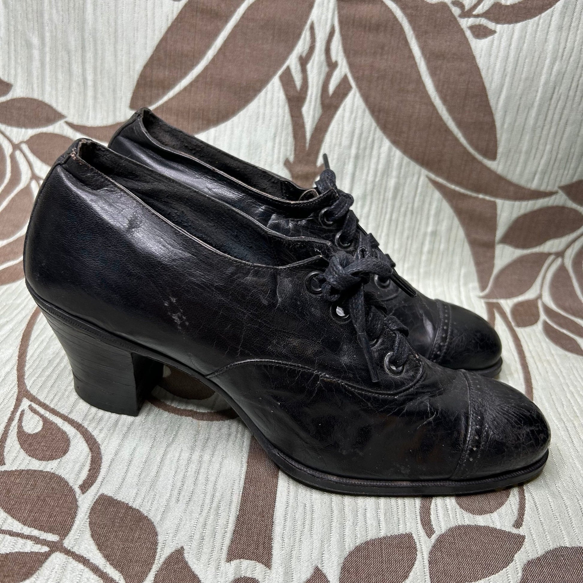 side view of Edwardian Ladies black leather lace up Oxford heeled shoes on patterned fabric - Splendid Vintage World