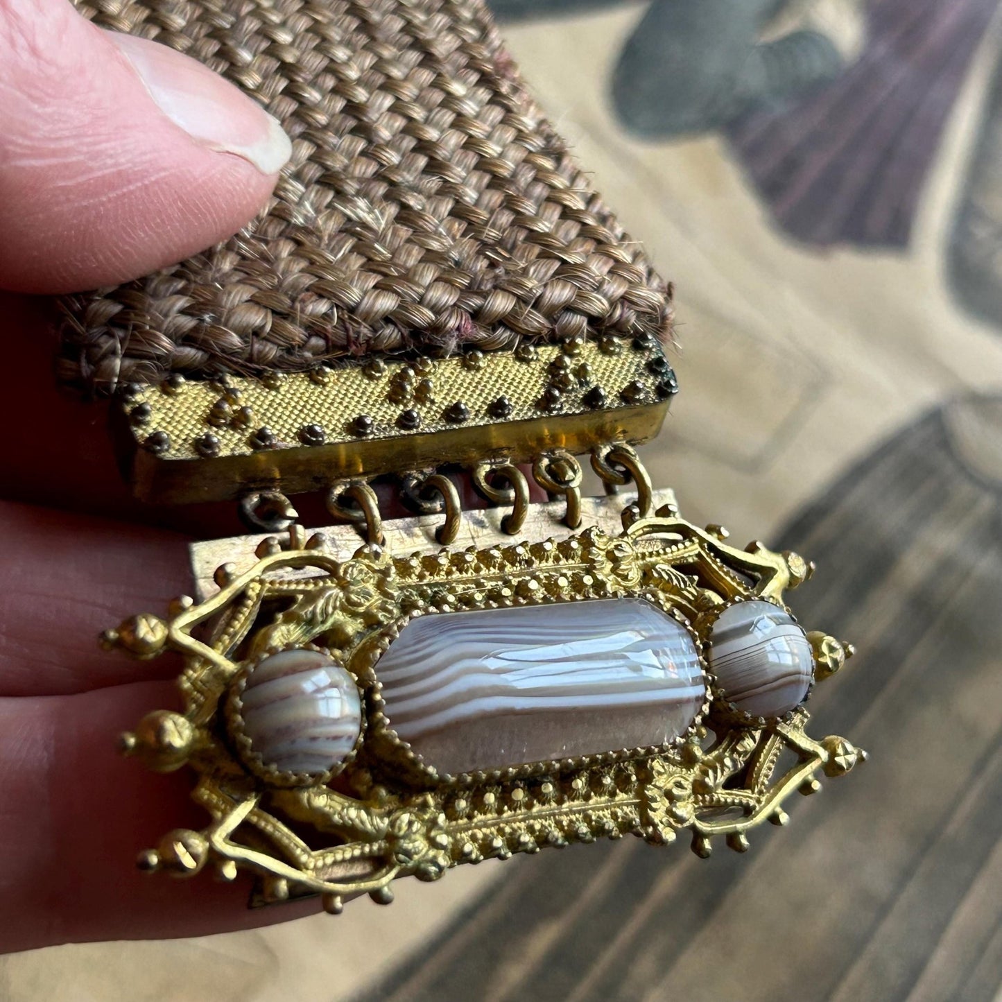 Antique Georgian Woven Hair Cuff Bracelet Gilt Metal & Agates held by hand on printed magazine - Splendid Vintage World
