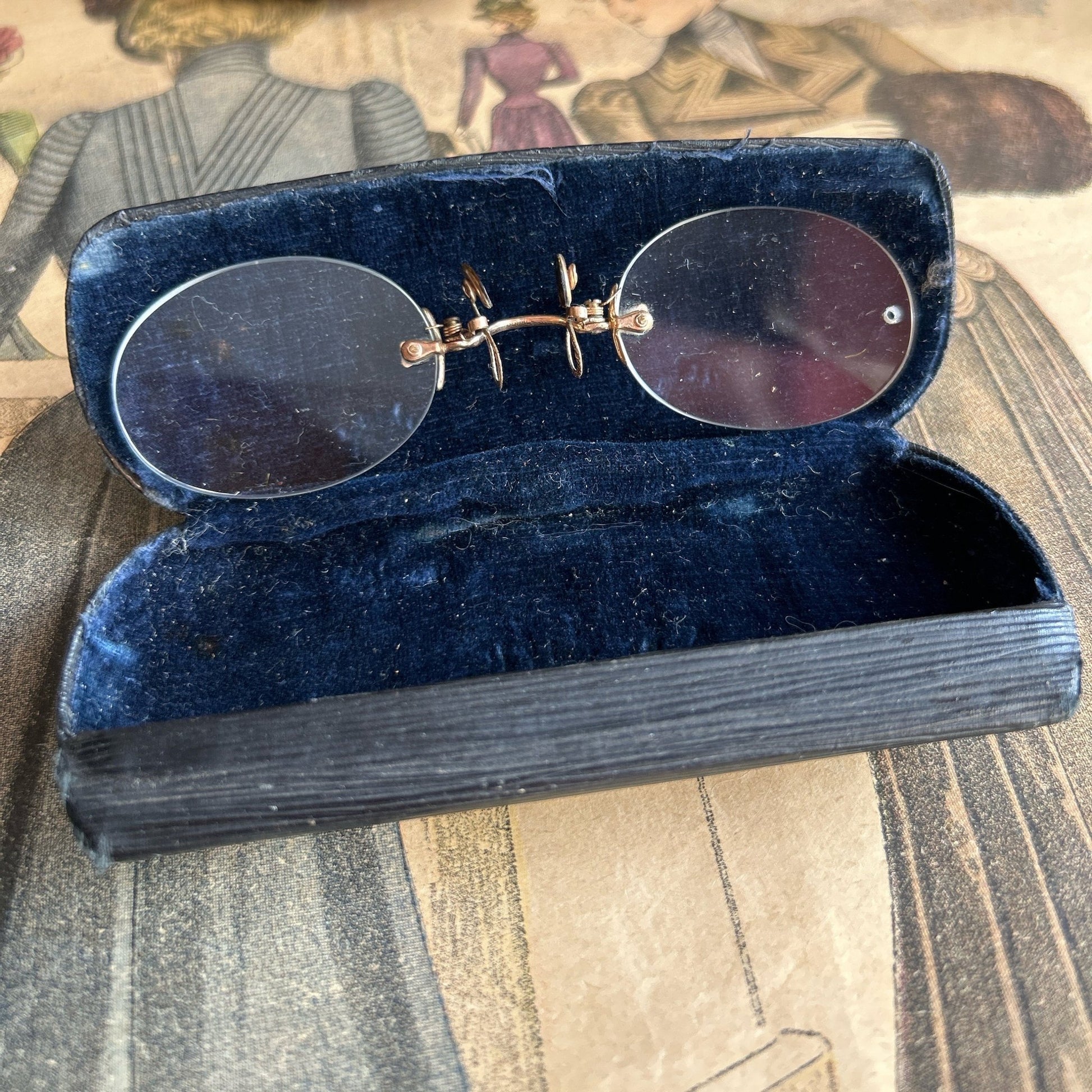 Antique Pince Nez Reading Spectacles in an open Case on an old colour printed fashion magazine - Splendid Vintage World
