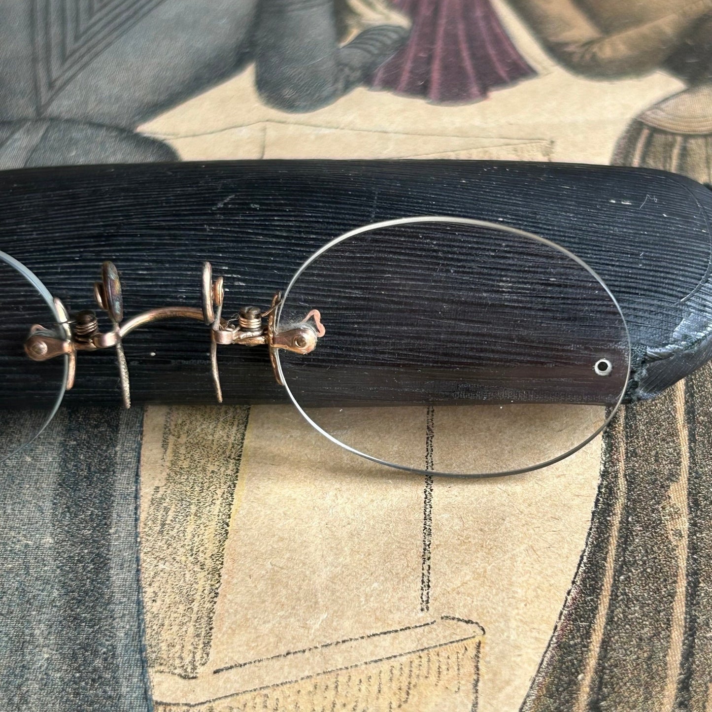 Antique Pince Nez Reading Glasses next to a glasses Case on printed clothing magazine - Splendid Vintage World