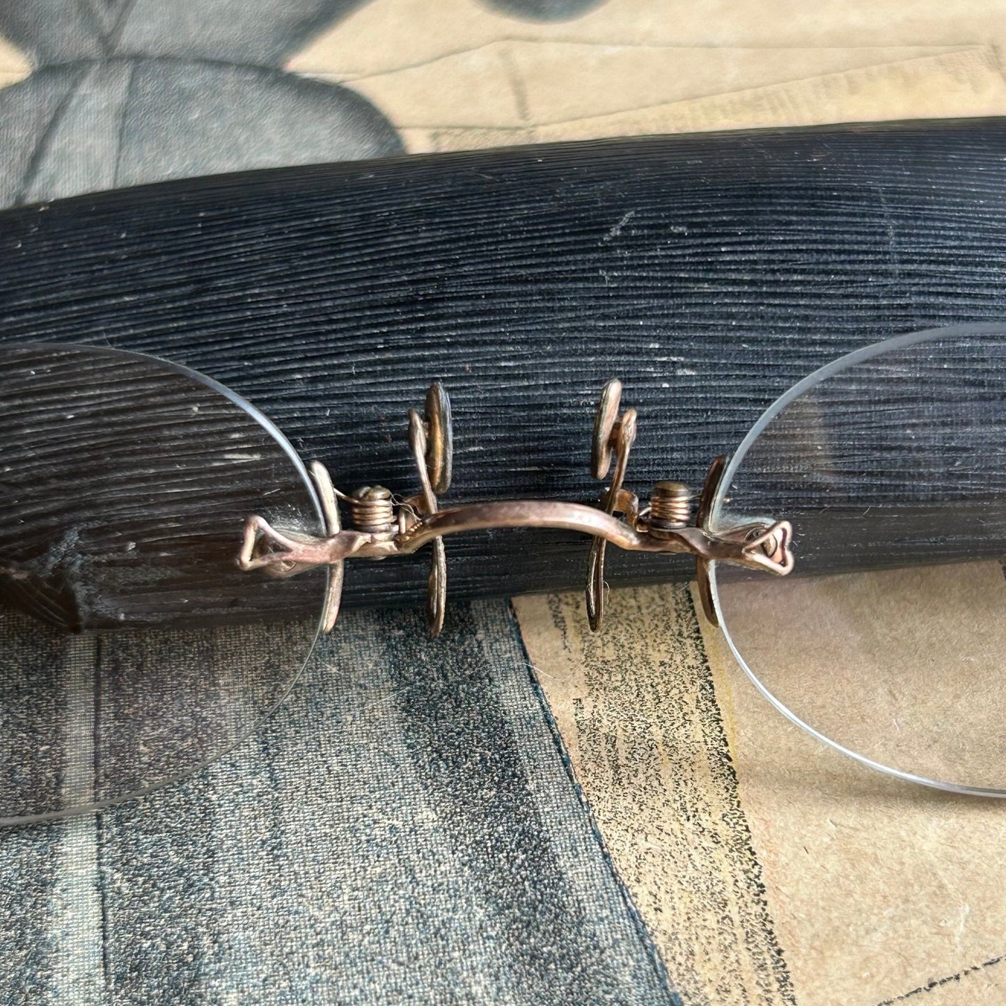 Antique Pince Nez Reading Spectacles next to a Case on printed magazine featuring a blue dress- Splendid Vintage World
