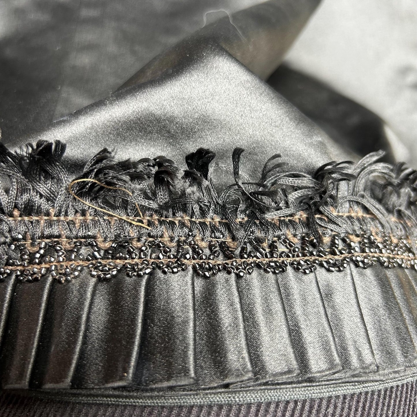 close up of black sateen pleated skirt hem detail and the bead & silk tuft trimmings - splendid vintage world