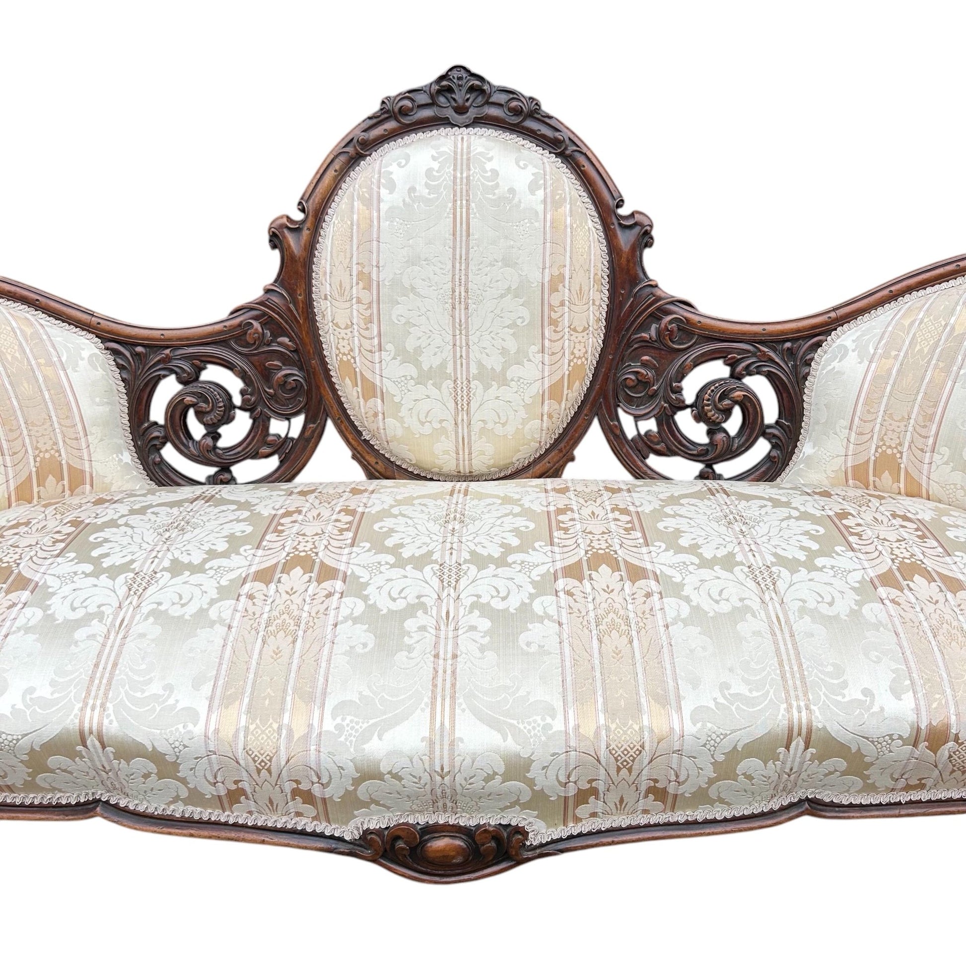 Centre close up of Victorian carved walnut cameo back sofa chaise upholstered in beautiful traditional damask