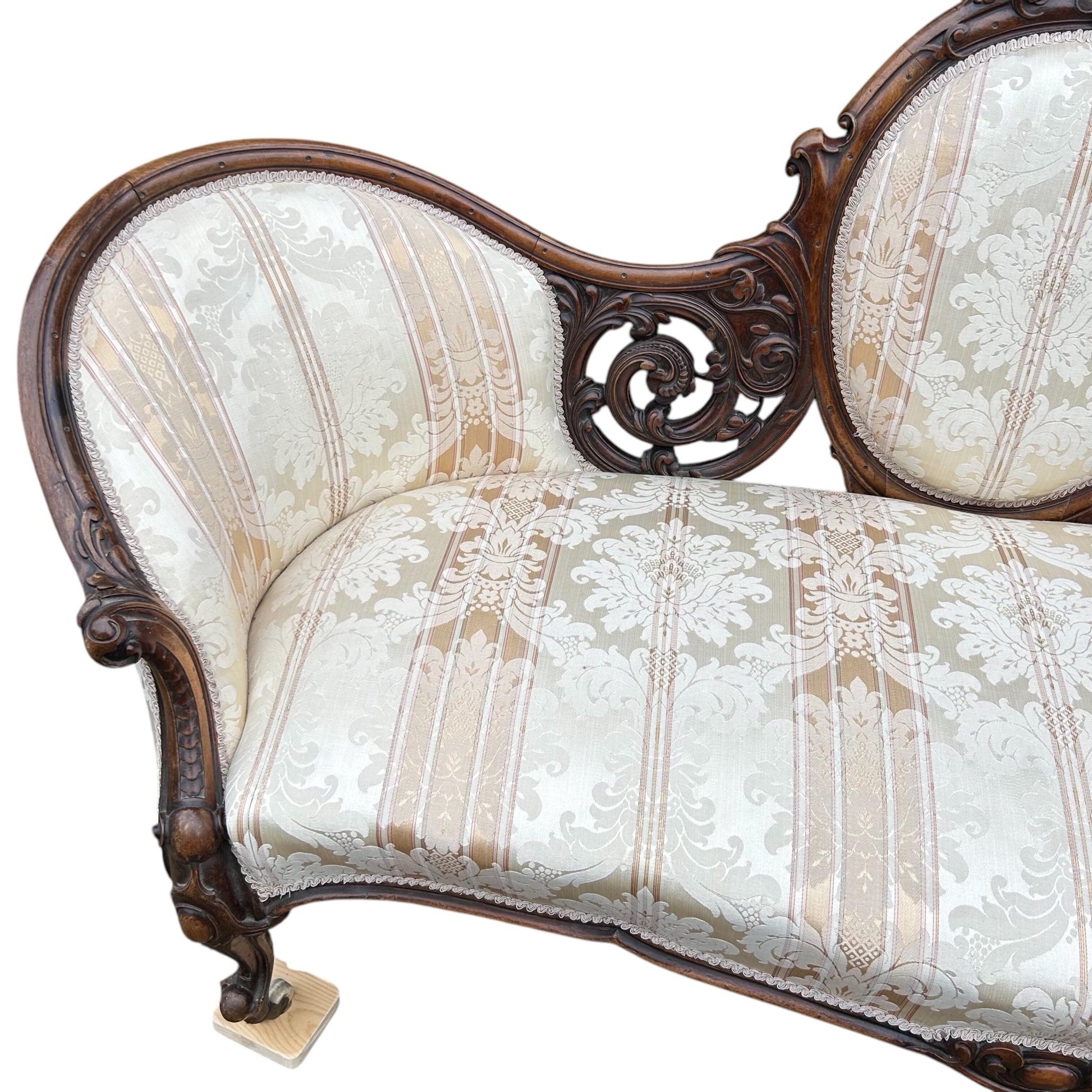 End close up of Victorian carved walnut cameo back sofa chaise upholstered in beautiful traditional damask