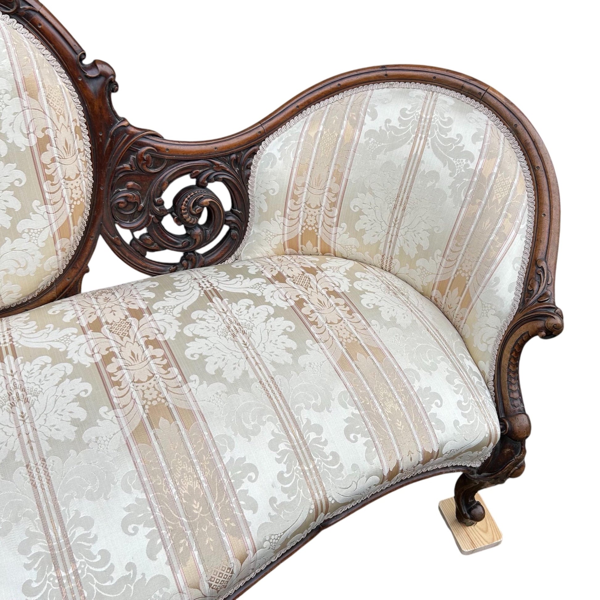 End close up of Victorian carved walnut cameo back sofa chaise upholstered in beautiful traditional damask