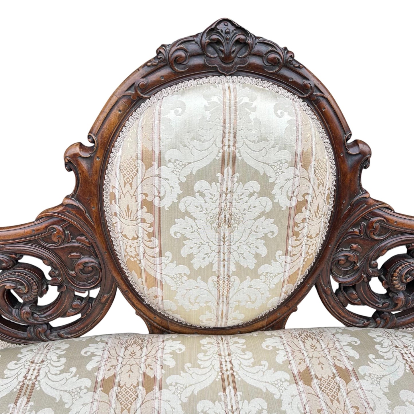 Centre close up of Victorian carved walnut cameo back sofa chaise upholstered in beautiful traditional damask
