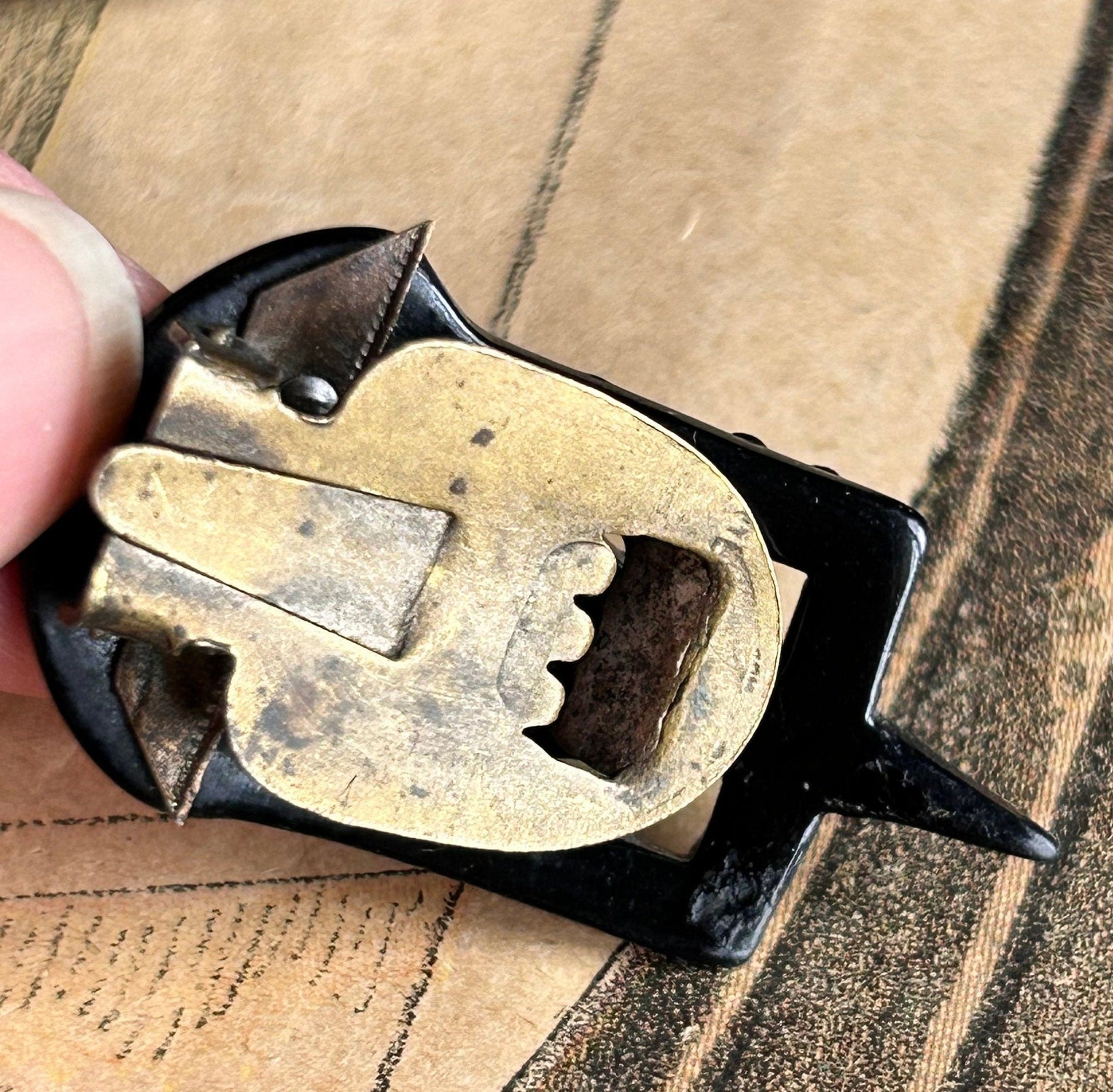 Back view of the metal clip of the dress clip held by a hand above an illustration- Splendid Vintage World