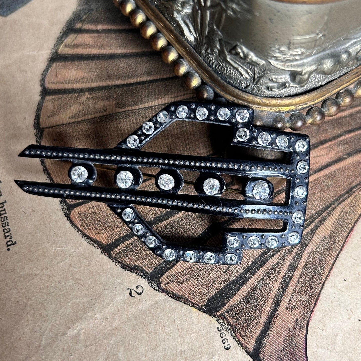 Art Deco black diamanté and fine pin detail on illustrated magazine background - Splendid Vintage World