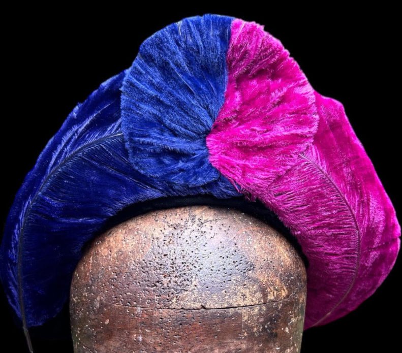 vibrant blue and pink ostrich feather hat brim on brown wooden head against black background- Splendid Vintage World