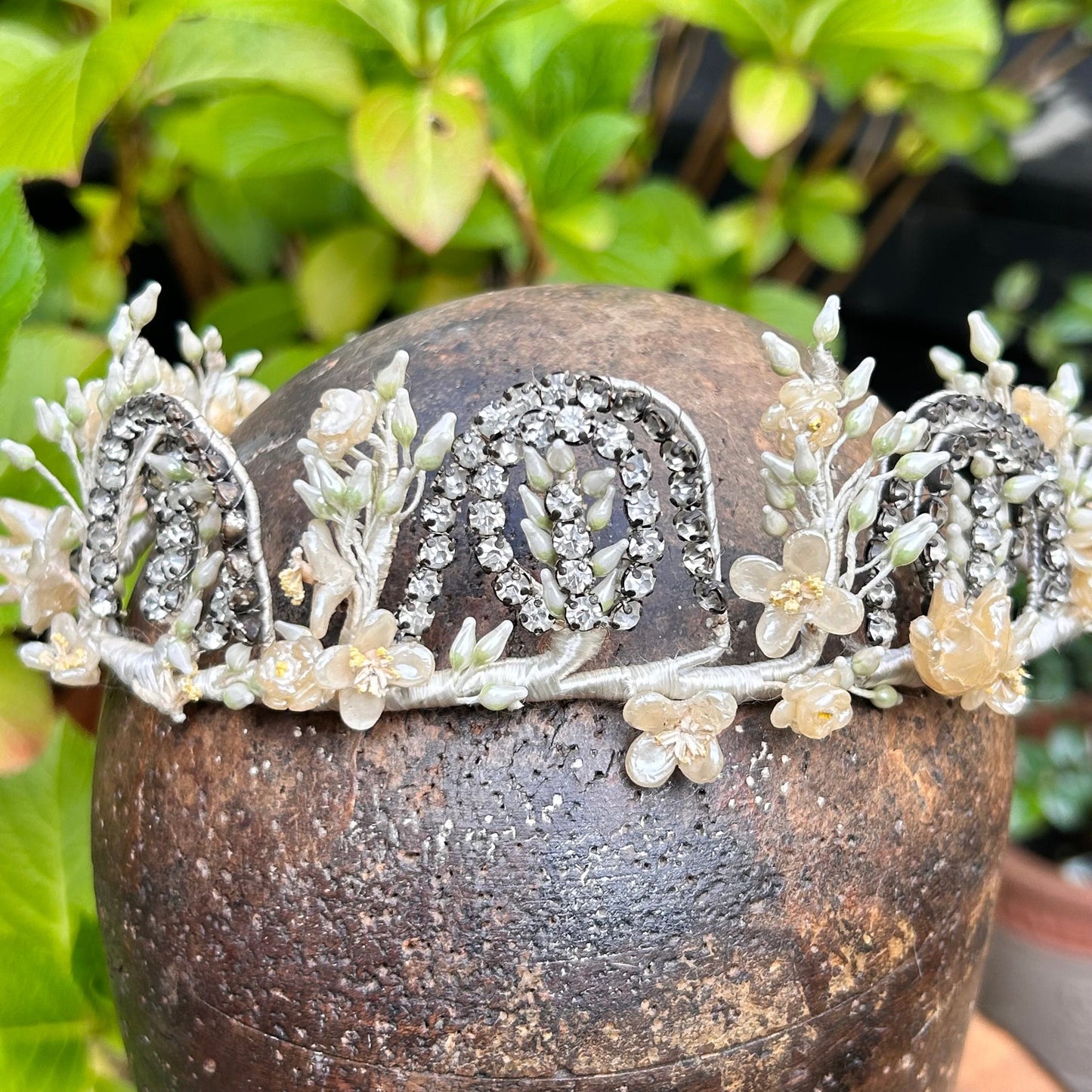 bridal crown tiara of diamanté, wax flowers & buds on wooden hat block with greenery background - Splendid Vintage World