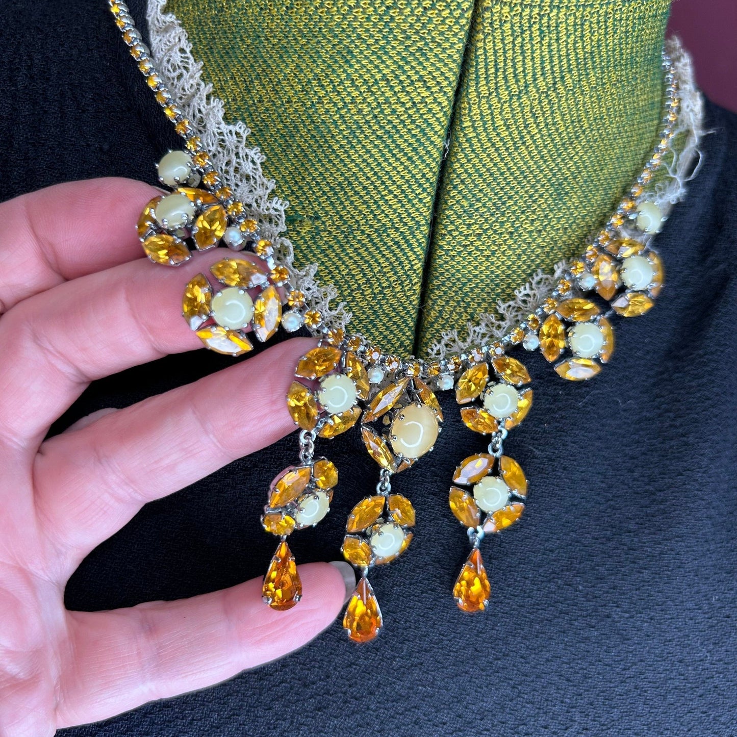 Citrine colour Necklace Floral Droplets & Faux Pearls on black dress & green mannequin held by hand - Splendid Vintage World