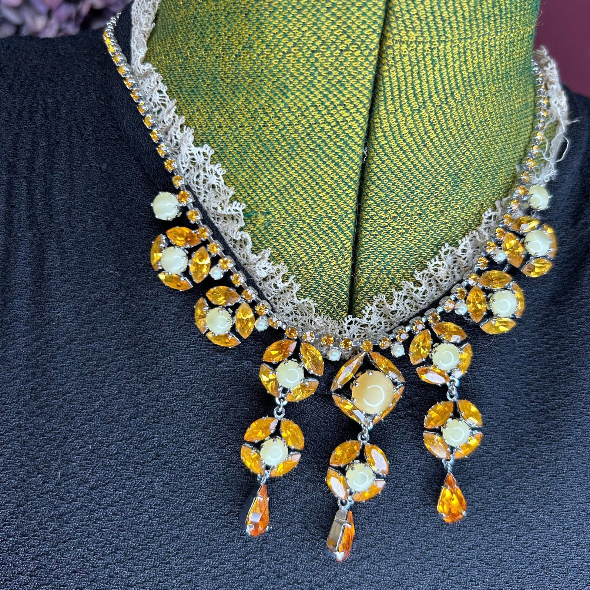 Citrine colour Necklace With Floral Droplets & Faux Pearls over black dress on green mannequin - Splendid Vintage World