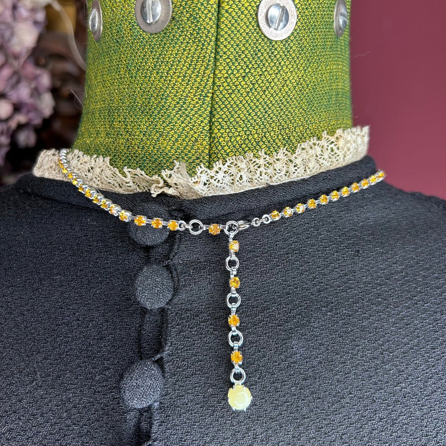 necklace chain fastening on black dress on green mannequin - Splendid Vintage World