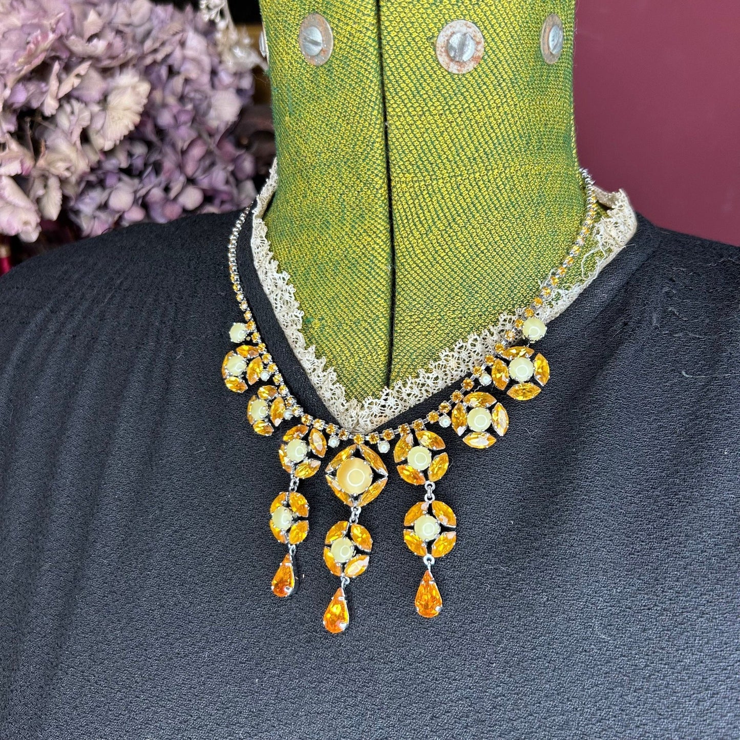 Citrine colour Necklace With Floral Droplets & Faux Pearls over black dress on green mannequin - Splendid Vintage World