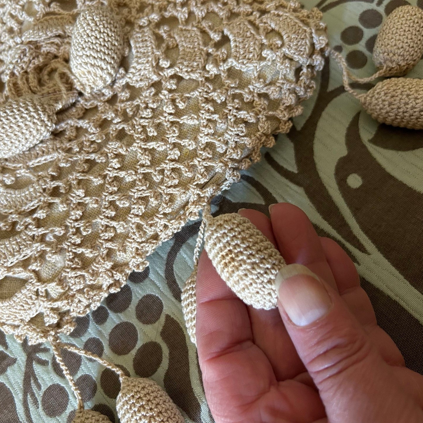 Vintage crochet handbag dimensional bobble in hand close up on patterned fabric - Splendid Vintage World