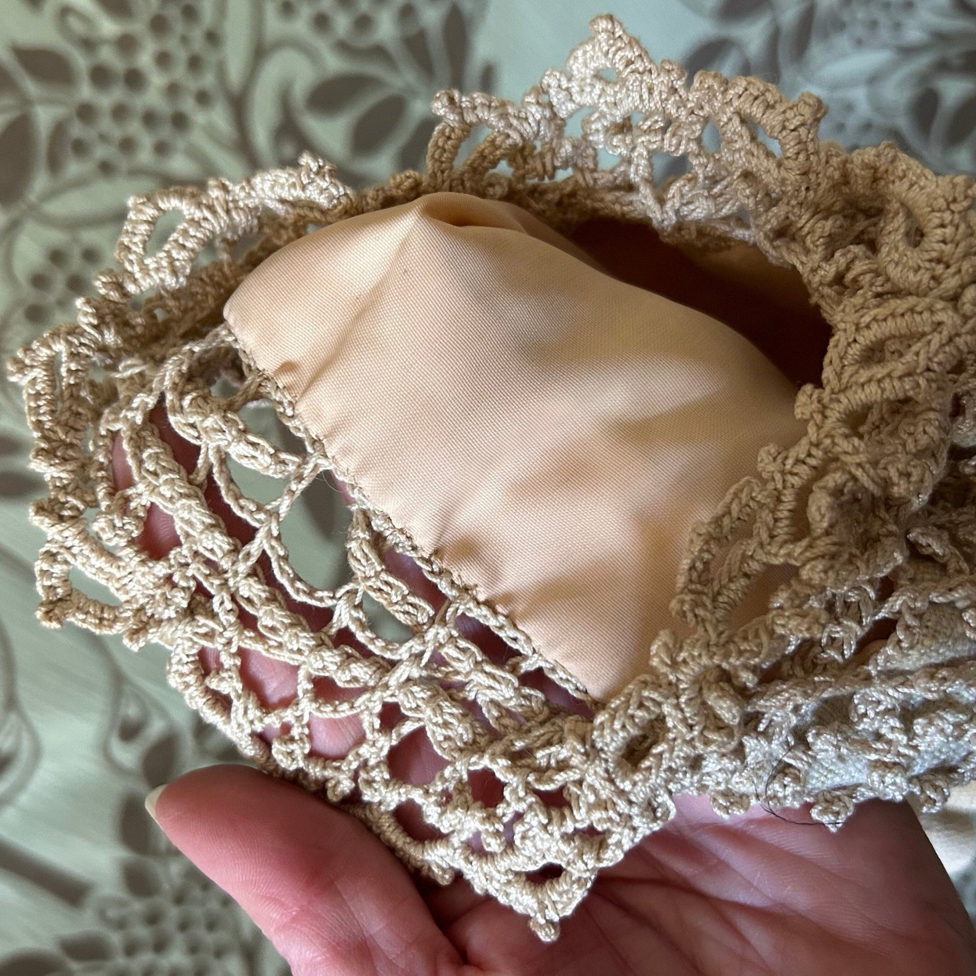 Vintage crochet handbag lining held by hand on patterned background - Splendid Vintage World