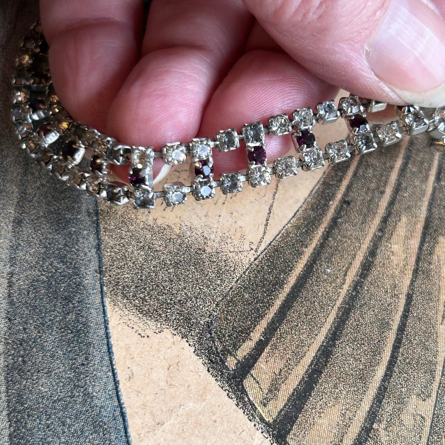 Vintage diamanté bracelet clear & amethyst paste held by hand on printed magazine - Splendid Vintage World
