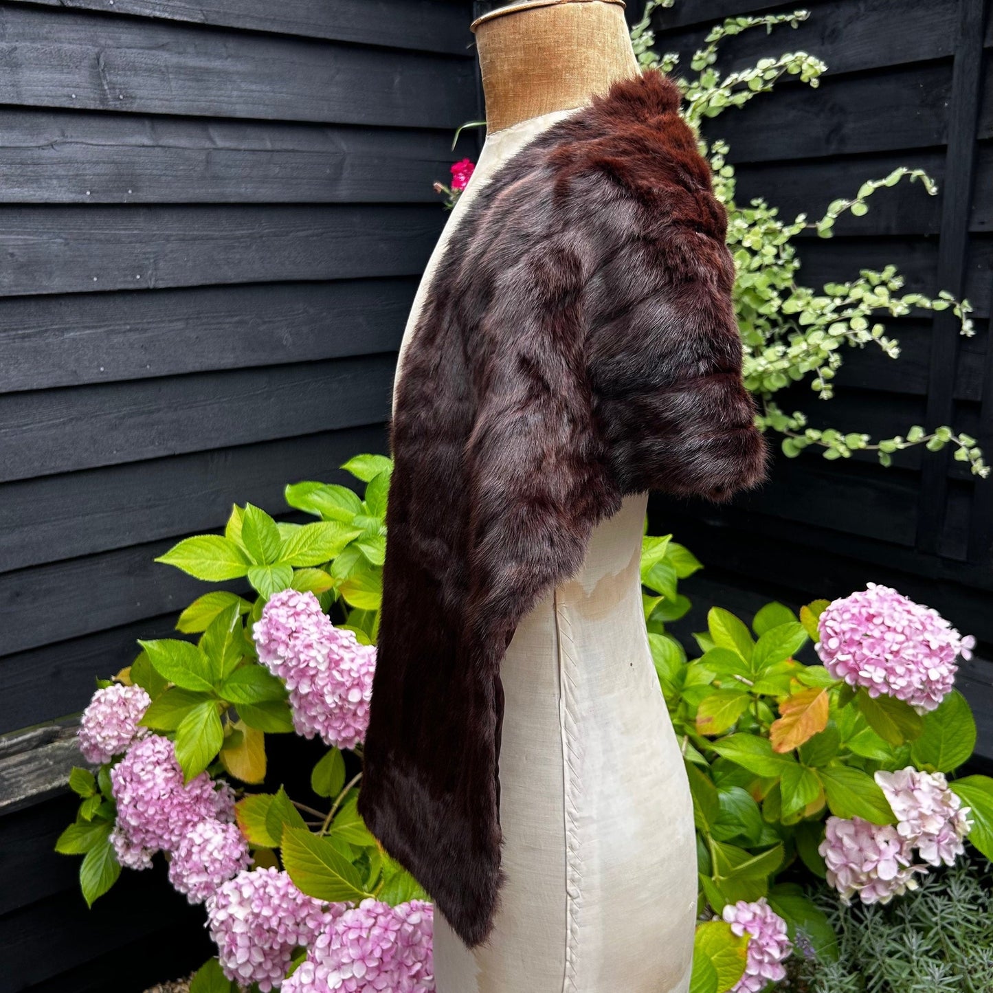 side view of Vintage Fur Stole Reddish Brown in colour on a mannequin in a garden - Splendid Vintage World