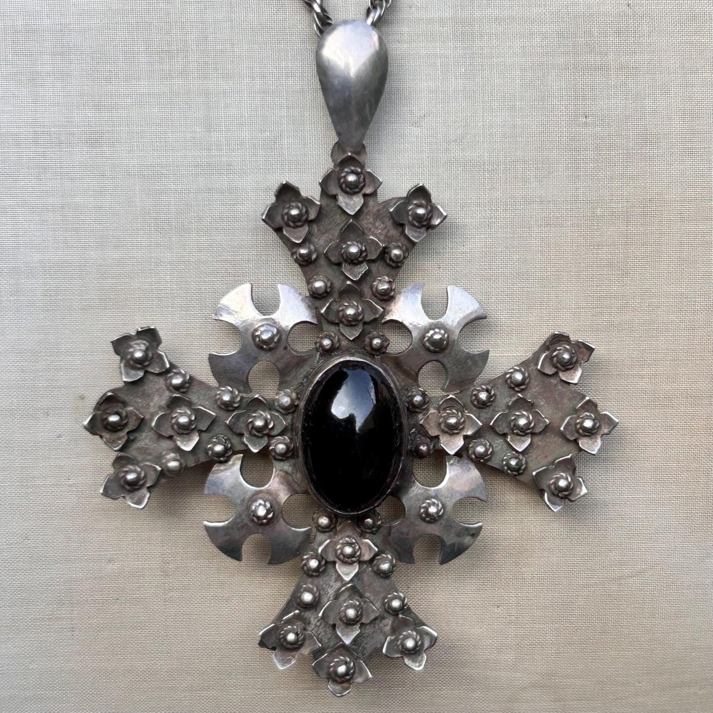 Vintage ornate silver cross pendant Set with black cabochon on silver rope chain on beige background - Splendid Vintage World