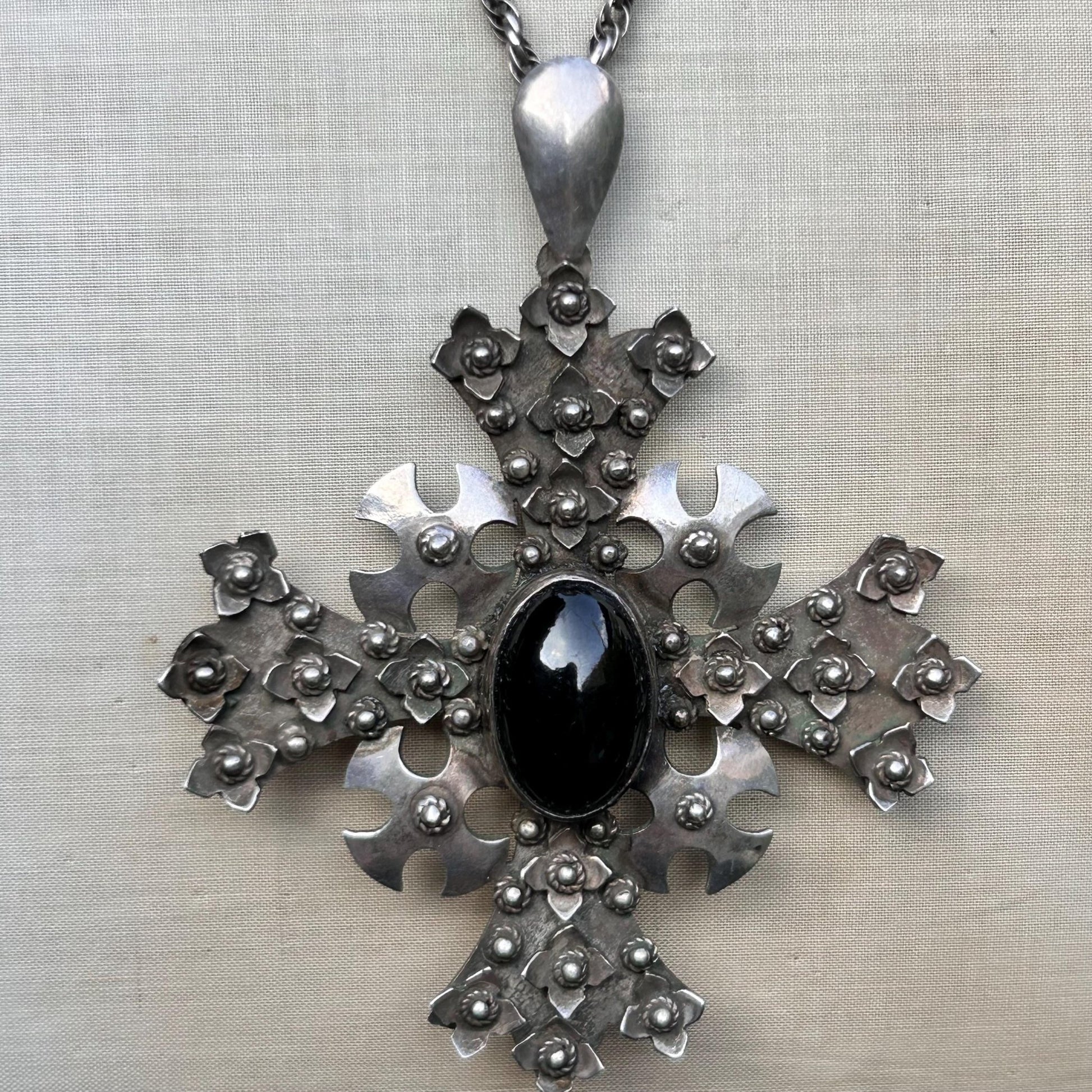 Vintage ornate silver cross pendant Set with black cabochon on silver rope chain on beige background - Splendid Vintage World