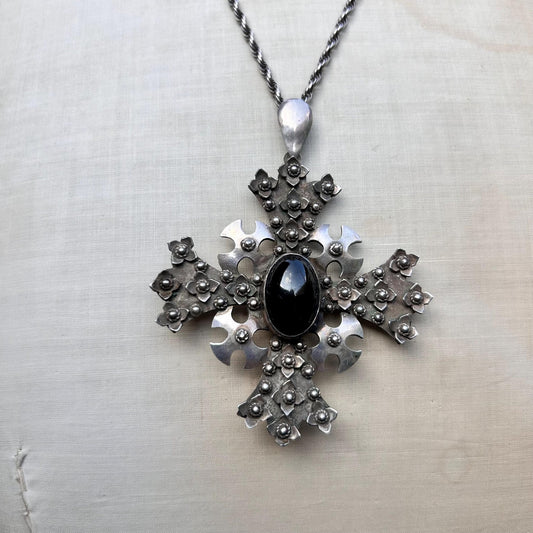 ornate silver cross pendant Set with oval black cabochon on silver rope chain on beige background - Splendid Vintage World
