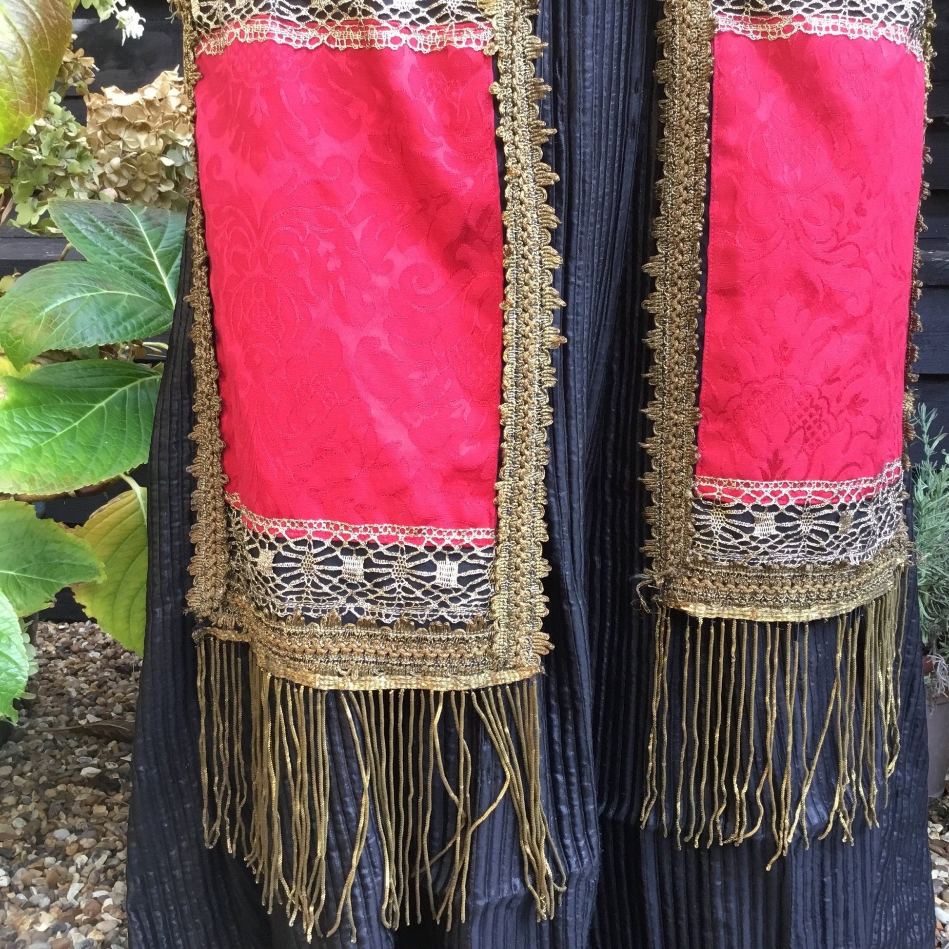 2 rectangular red textile panels edged in gold trim & Bullion Fringe on black textile & greenery - Splendid Vintage World