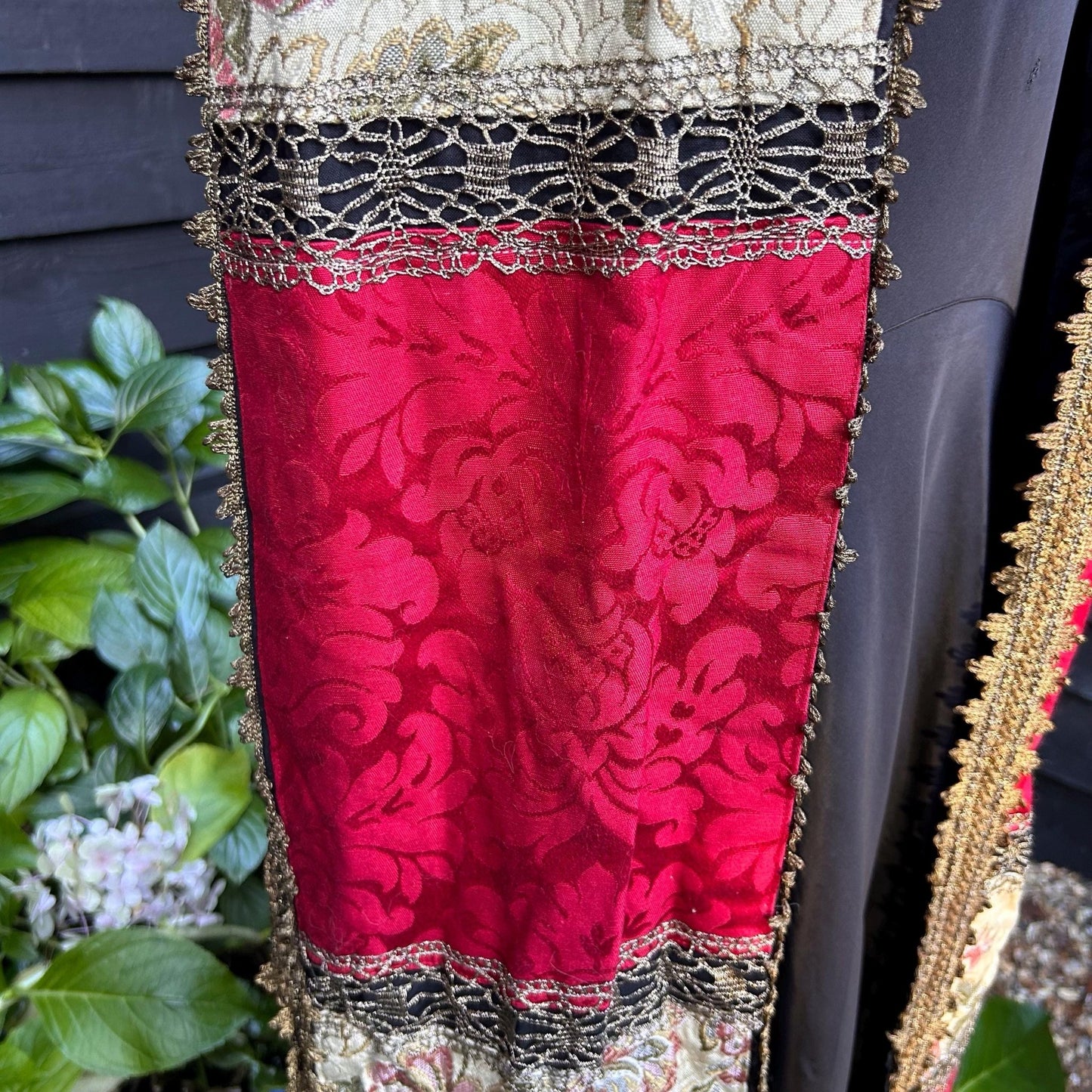 red patterned fabric with Gold Trim edge & beige fabric strips & black stripe with greenery behind - Splendid Vintage World